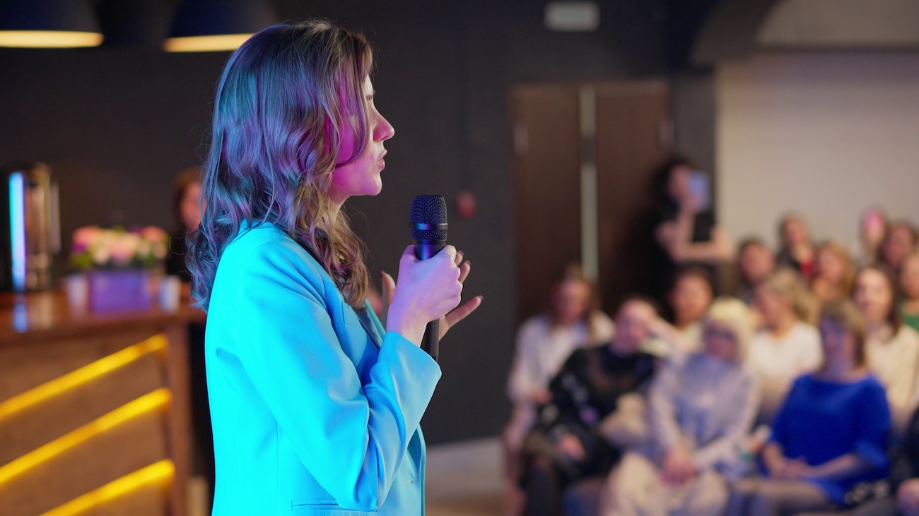 Woman using storytelling to inspire a crowd at a conference
