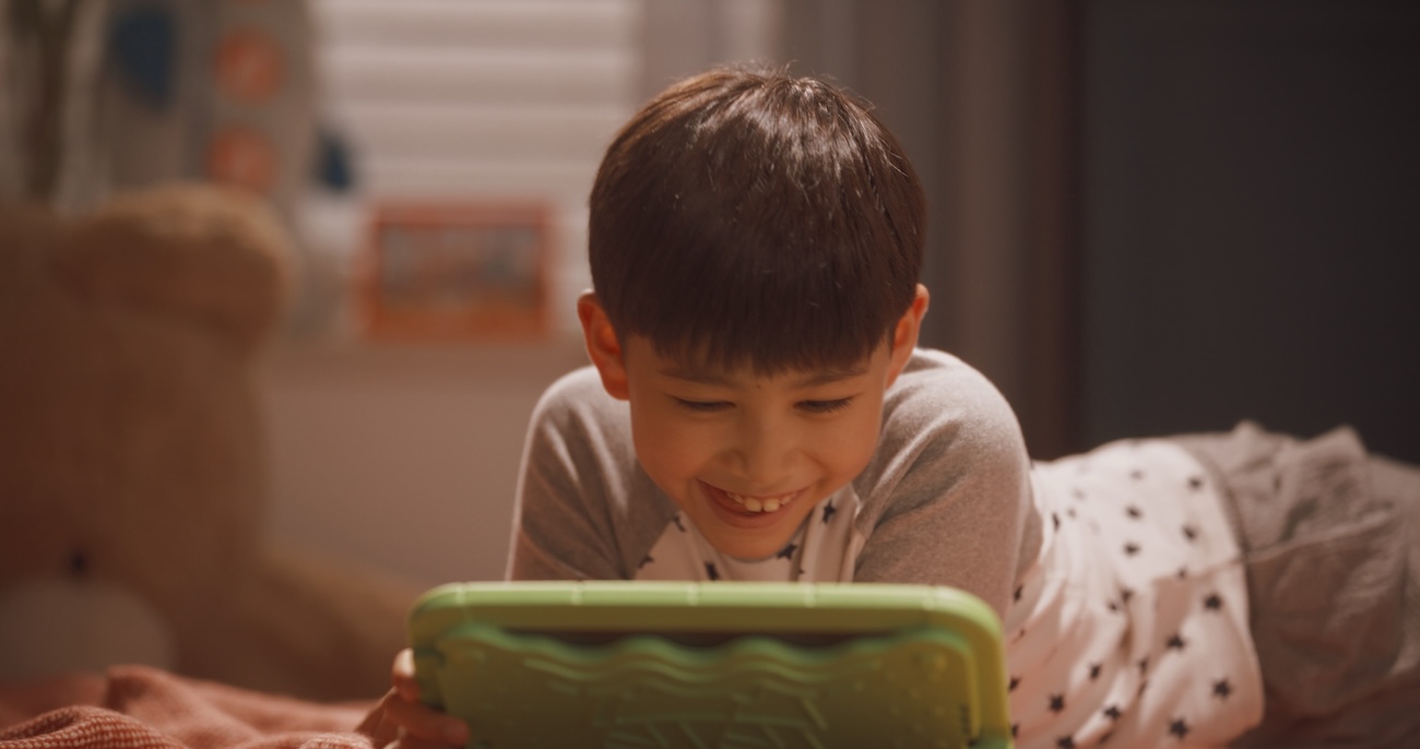 boy at home learning on a tablet reading a story